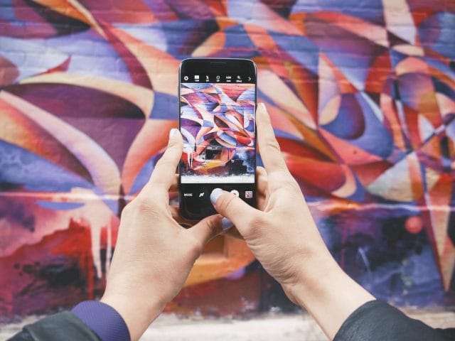 Navigating the Filipino Social Media Scene: Discovering the Best Social Media Platform for Your Brand | Lime Digital Asia person holding Android smartphone and taking a photo of abstract wall during daytime