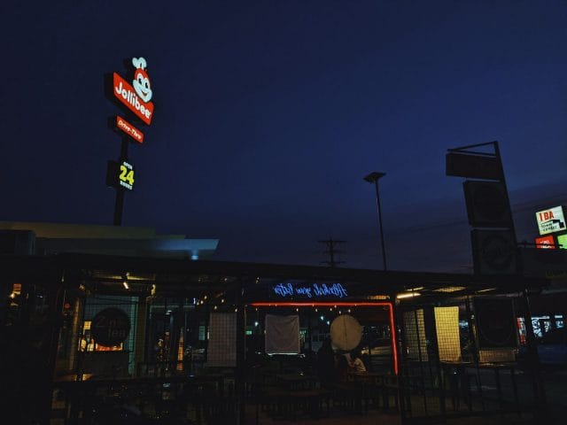 a restaurant at night with neon signs and a dark sky